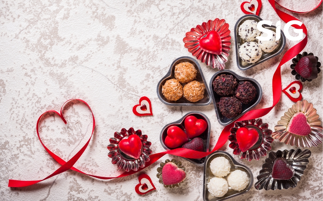 A heart-shaped plate filled with fresh strawberries, dark chocolate, and mixed nuts, symbolizing healthy and natural Valentine's Day snack options.